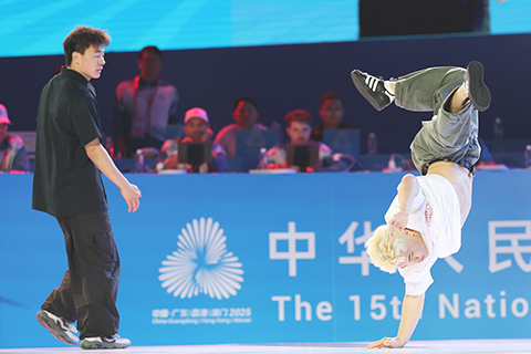 ◎ 十一月十九日晚,全運會霹靂舞男子組決賽在廣州舉行,湖北隊選手王瑞苗戰勝賽前「大熱門」江蘇隊選手亓祥宇摘金。圖為王瑞苗(右)和亓祥宇在比賽中。(中新社記者盛佳鵬 攝)