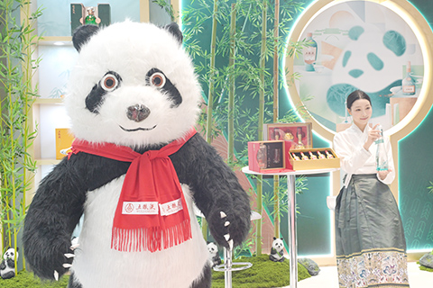 場外「熊貓文創集市」「熊貓夥伴攝影展」等展覽吸引中外嘉賓駐足欣賞或拍照留念。圖為熊貓布偶與酒文化巧妙融合。(中新社記者 劉忠俊 攝)