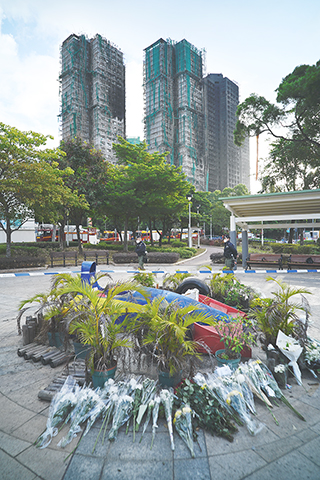 ◎ 這是十一月廿九日清晨在火災後的大埔宏福苑樓宇附近拍攝的市民寄託哀思的花束。 大埔宏福苑火災發生後,香港市民以多種方式悼念大埔宏福苑火災中罹難者。(新華社發 王申 攝)