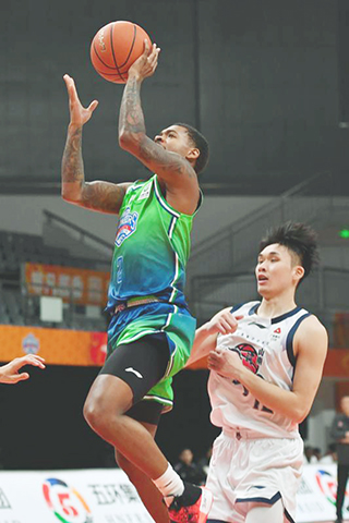 ◎ 十二月三日,天津先行者隊球員哈姆雷特(左)上籃。在第二屆CBA俱樂部杯賽湖南長沙賽區的比賽中,山東高速隊一百零六比九十戰勝天津先行者隊。(新華社記者 陳振海 攝)