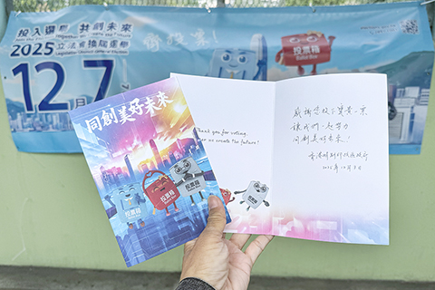 ◎ 十二月七日,香港特區舉行第八屆立法會換屆選舉,投票市民可獲政府送贈一張心意謝卡,不少市民拿著心意卡在票站外拍照留念。(香港中通社記者徐文峰 攝)
