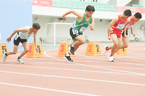 ◎ 十二月十日,全國第十二屆殘疾人運動會暨第九屆特殊奧林匹克運動會特奧田徑在廣東省中山市開賽,澳門運動員王德康在男子十二至十五歲組一百米決賽-第2組比賽中奪冠。圖為王德康(五道)在比賽中。(中新社記者 陳楚紅 攝)