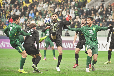 ◎ 十二月十一日,雙方球員在比賽中拼搶。在北京舉行的亞冠二級聯賽小組賽E組比賽中,中國北京國安隊一比二不敵澳大利亞FC麥克阿瑟隊(黑衣)。(中新社記者 趙文宇 攝)