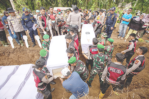 ◎ 印度尼西亞國家抗災署十二月十三日的統計數據顯示,該國北蘇門答臘省、西蘇門答臘省和亞齊省近日遭遇的洪災和山體滑坡已造成一千零三人遇難、二百十八人失蹤。圖為十一日,在印度尼西亞西蘇門答臘省,警察為遇難者舉行集體葬禮。(新華社發 安德里.馬迪安賽亞 攝)