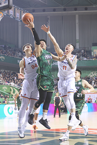 ◎ 十二月十六日晚,在江蘇南京舉行CBA常規賽中,南京天之藍隊主場一百零五比九十七戰勝上海久事隊。圖為南京天之藍隊球員黃榮奇(中)爭搶。(中新社記者 泱波 攝)