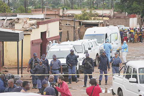 ◎ 十二月廿一日,南非貝克斯達爾一家酒吧發生大規模槍擊事件,槍手造成九人死亡,至少十人受傷,南非警方聚集在現場。(美聯社圖片/Alfonso Nqunjana)