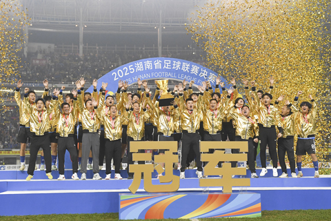 ◎ 十二月二十七日晚,湖南省足球聯賽在長沙賀龍體育場落幕,永州隊最終以一比0擊敗常德隊,奪得「湘超」冠軍。圖為永州隊舉起冠軍獎杯。(中新社記者 楊華峰 攝)