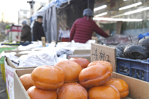 2026年1月3日,吉林省吉林市,市場上售賣的凍柿子和凍梨。(中新社記者 石洪宇 攝)