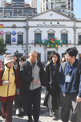 ◎ 一月八日,畢飛宇(左二)在澳門議事亭前地廣場與入選「澳門故事-青年作家在地創作培育計劃」的學員們交流。(中新社記者 鄭嘉偉 攝)