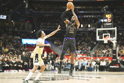 ◎ 洛杉磯湖人隊前鋒勒邦占士(23)在一月三十日於華盛頓舉行的NBA常規賽下半場中,突破華盛頓巫師隊後衛比拉爾.庫利巴利封阻(左)投籃。(美聯社/尼克.瓦斯)