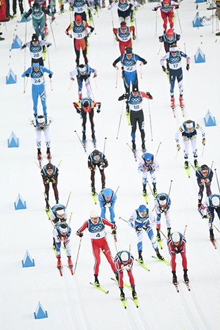 ◎ 二月二十一日,選手們在比賽中出發。冬奧會越野滑雪男子五十公里集體出發(傳統技術)比賽在意大利泰塞羅舉行。(新華社記者 賀燦鈴 攝)