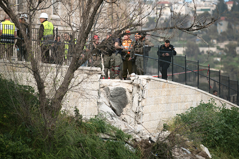 ◎ 三月二十日,耶路撒冷多次響起防空警報,耶路撒冷老城附近一處地點在導彈襲擊中受損。圖為當日,在耶路撒冷老城附近,應急反應人員在一處被導彈碎片波及的地點開展工作。(新華社記者 陳君清 攝)