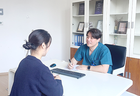 3月18日,韓國醫生金碩煥(右)正在診室接待就診者。 (受訪者 供圖)