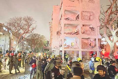 ◎ 三月廿一日晚,在以色列南部城市阿拉德,應急反應人員在一處導彈襲擊點開展工作(手機照片)。以色列南部城市迪莫納和阿拉德當晚遭導彈襲擊。當地急救組織稱,兩地已有超百人受傷送醫。以媒稱,以軍承認未能攔截到伊朗導彈。(新華社發)