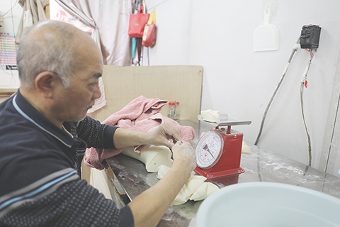 ◎ 三月十六日,位於台北南昌路二段的吉家火燒店,今年六十三歲的吉廷武將麵糰分成大小一致的劑子。(中新社記者 劉大煒 攝)