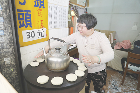 ◎ 三月十六日,位於台北南昌路二段的吉家火燒店內,今年五十八歲的方新梅正在烙「杠子頭」火燒。(中新社記者 劉大煒 攝)