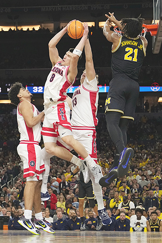 ◎ 四月四日在印第安納波利斯舉行的NCAA大學籃球錦標賽半決賽四強賽的下半場比賽中,亞利桑那州的伊万·哈琴科夫(Ivan Kharchenkov)(8)在密西根州的小莫雷茲·約翰遜(Morez Johnson Jr.(21))防守下搶籃板球。(美聯社/邁克爾康羅伊)