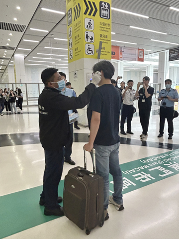 ◎ 「防控接觸傳播疾病聯合演習」的情況-口岸衛生檢疫人員為旅客覆測體溫。
